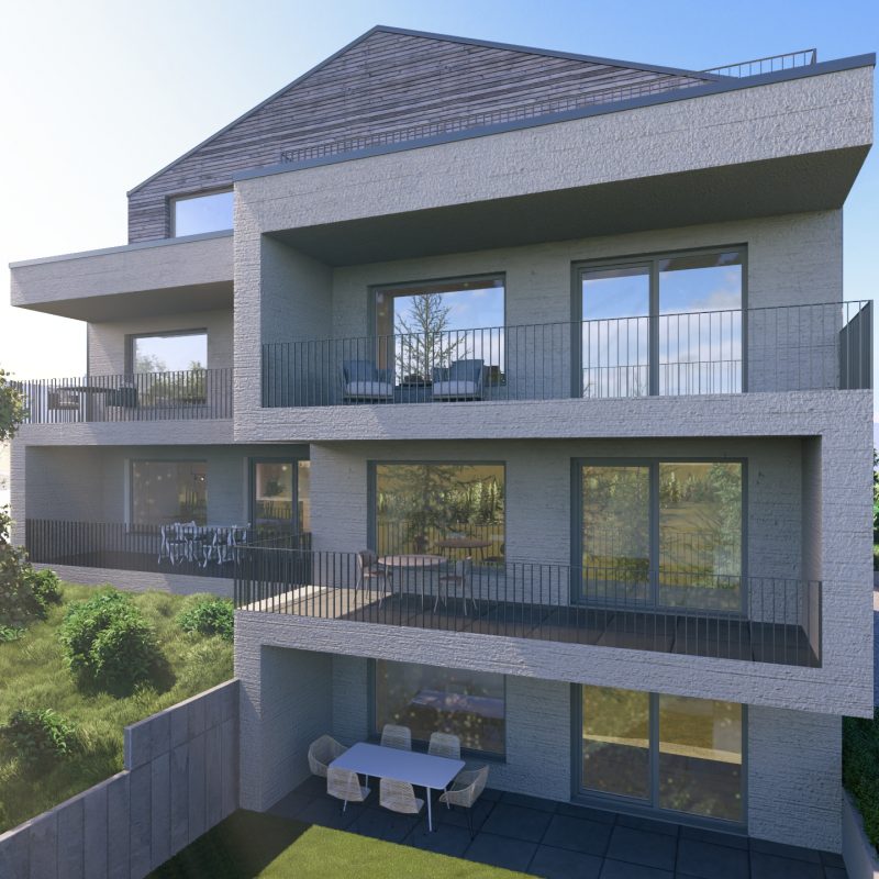 Mehrfamilienhaus mit Balkonen und Terrassen auf drei Ebenen, umgeben von Grün und Abendlicht.